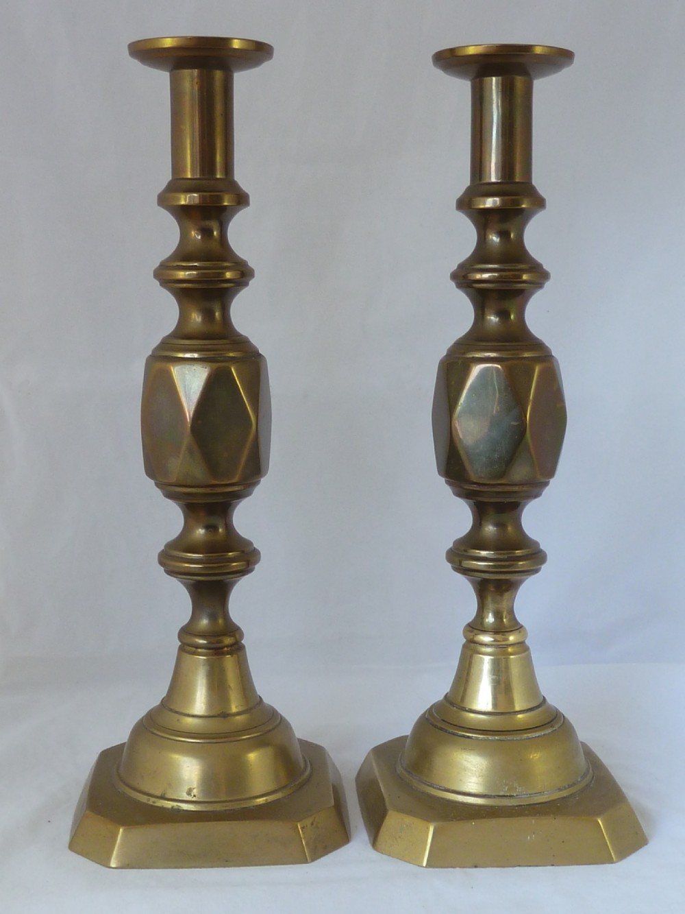 A pair of 14-inch Victorian cast brass candlesticks featuring faceted diamond-shaped centre knops and octagonal stepped bases. View III