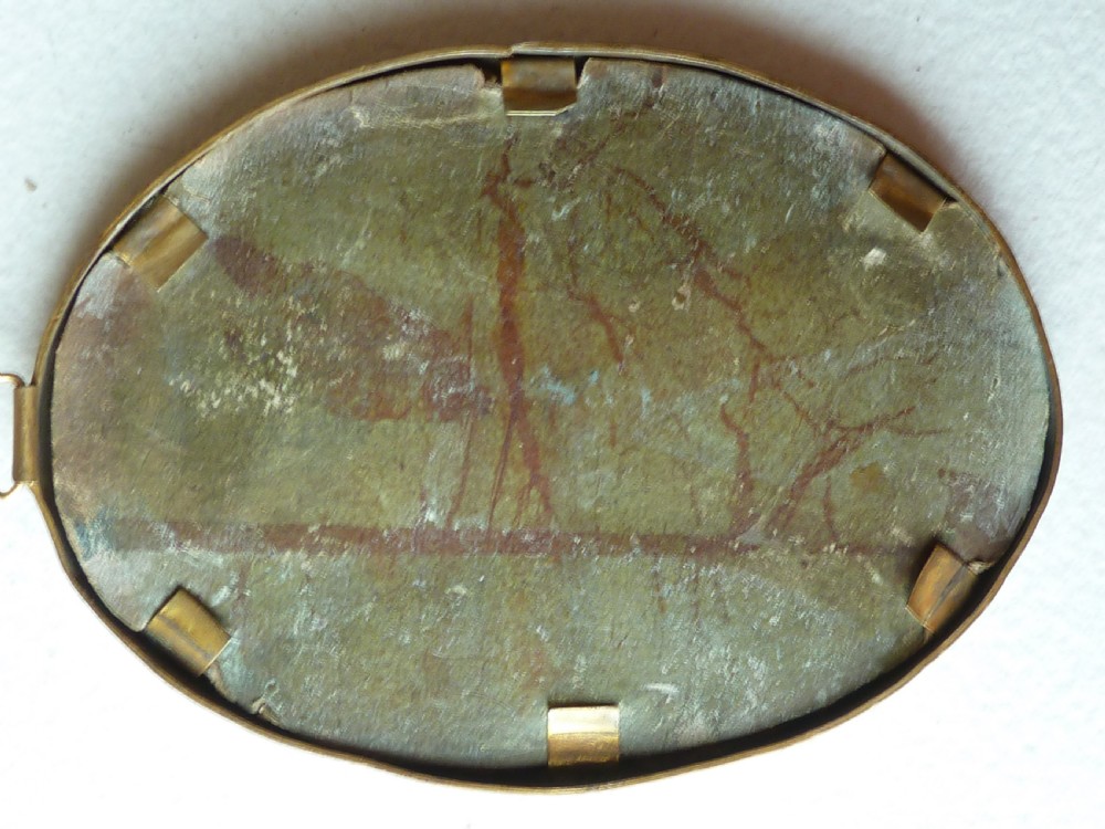 An oval Art Deco portrait miniature depicting a woman with short dark bobbed hair set in a plain brass frame. View IV