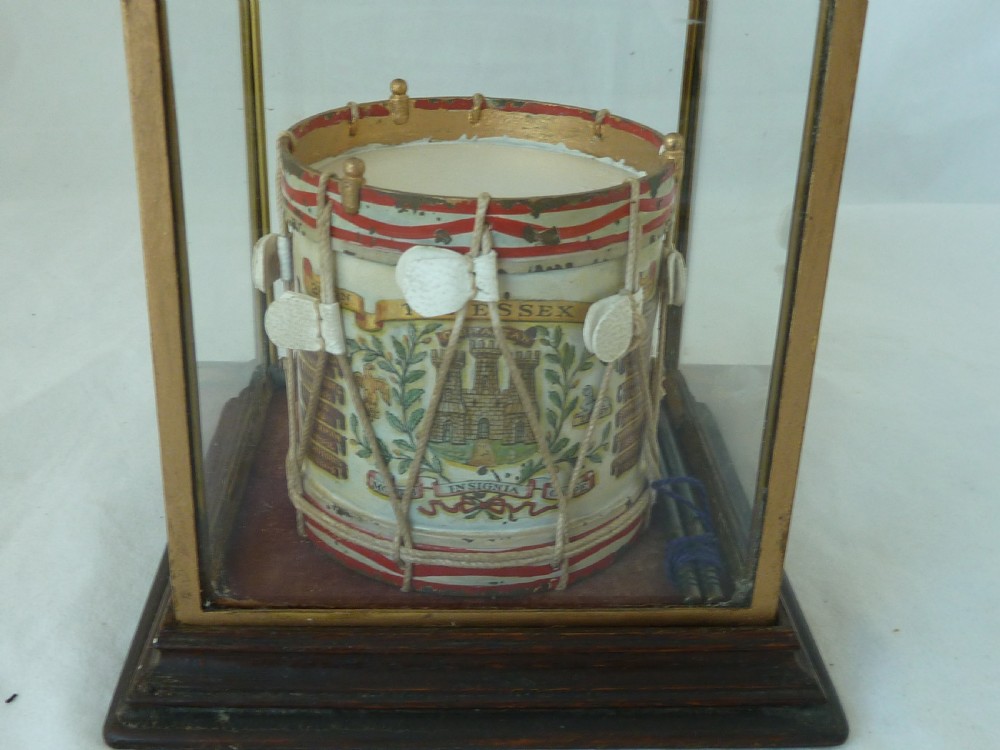 A miniature painted regimental snare drum with rope tensioning enclosed within a brass-bound glass display case on a dark timber base. View II