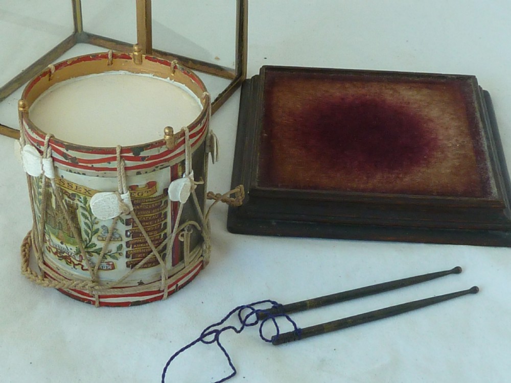 A miniature painted regimental snare drum with rope tensioning enclosed within a brass-bound glass display case on a dark timber base. View IV