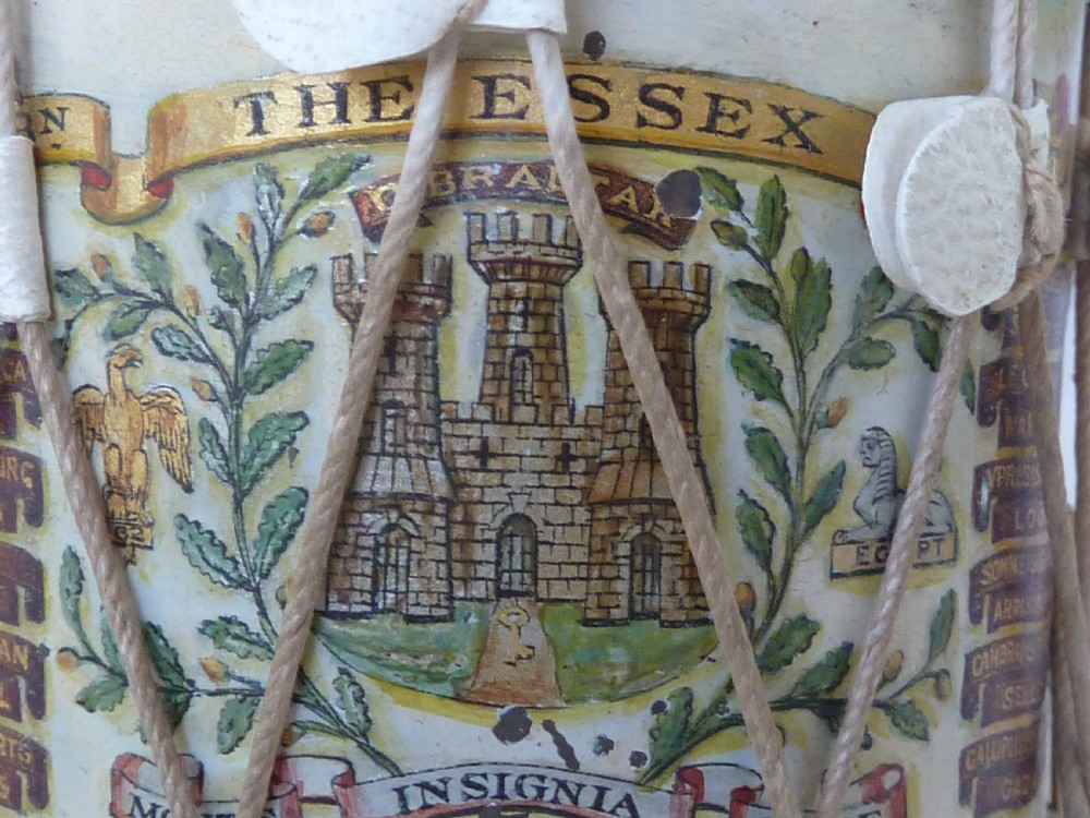 A miniature painted regimental snare drum with rope tensioning enclosed within a brass-bound glass display case on a dark timber base. View VII