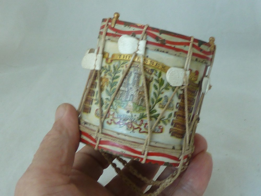 A miniature painted regimental snare drum with rope tensioning enclosed within a brass-bound glass display case on a dark timber base. View X