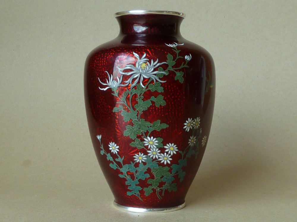 A crimson red translucent enamel vase decorated with silver wire chrysanthemums and silver rims.