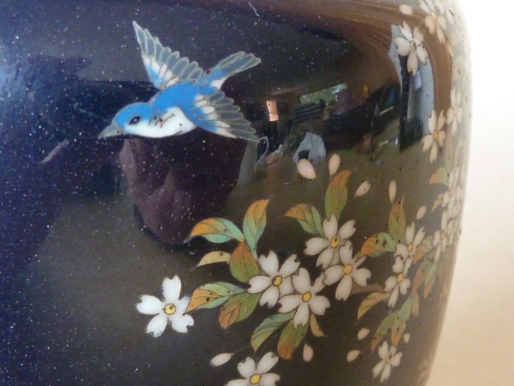 A black Japanese cloisonne enamel vase decorated with silver wire depicting white blossoms, foliage, and birds, finished with silver rim and foot rim. View II
