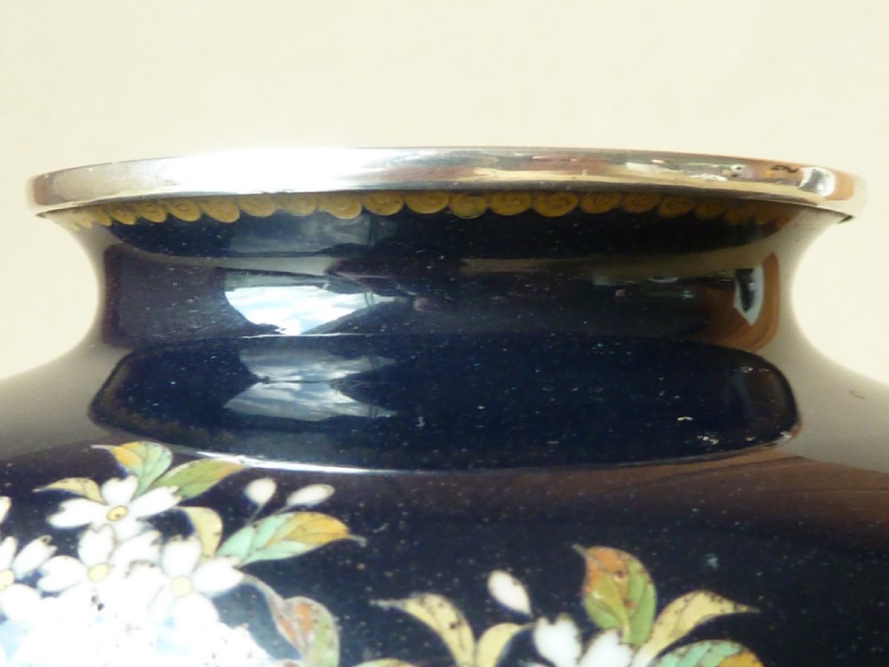 A black Japanese cloisonne enamel vase decorated with silver wire depicting white blossoms, foliage, and birds, finished with silver rim and foot rim. View VII
