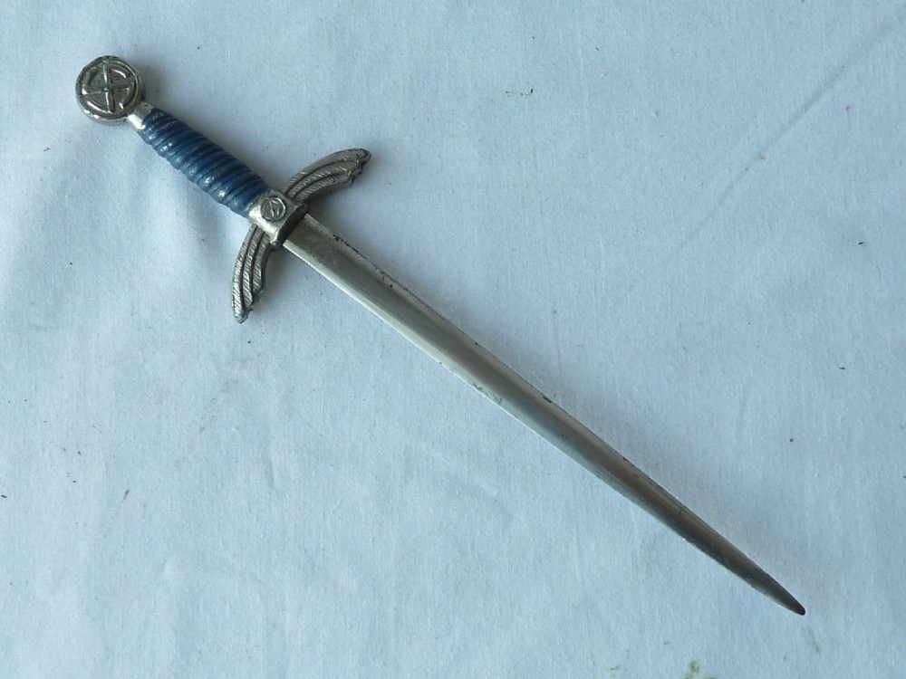 A miniature dagger letter opener featuring a tapered steel blade, down-swept crossguard, ribbed blue handle, and circular pommel. View II