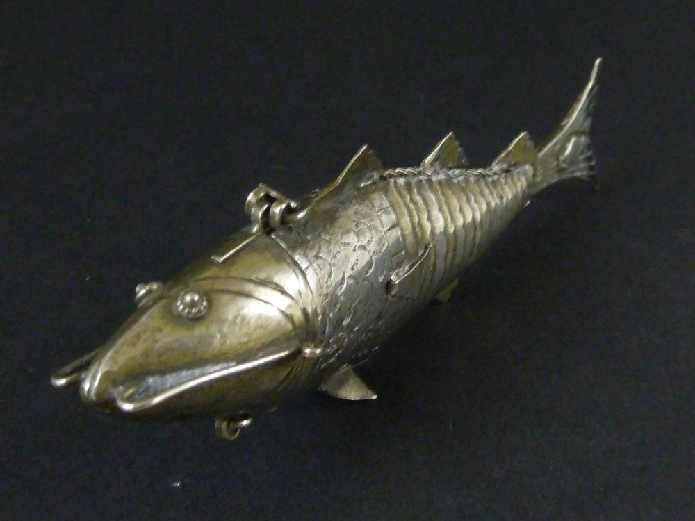 An articulated silver spice box crafted in the form of a detailed fish with overlapping scales and fins. View III