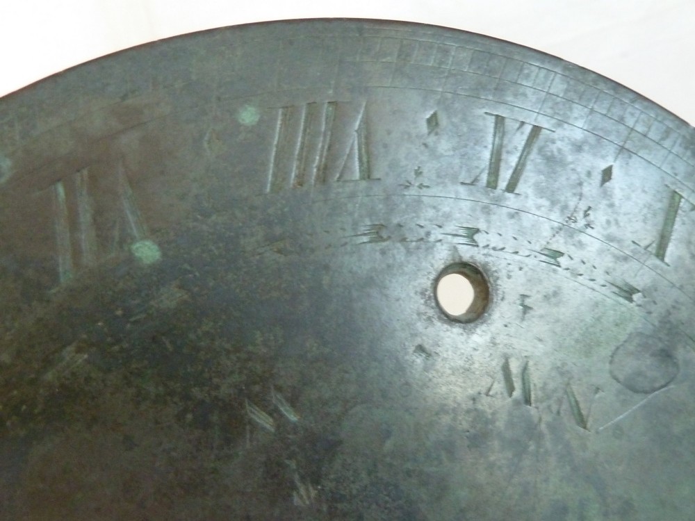 A circular weathered bronze sundial plate with a central triangular gnomon, engraved Roman numerals, and a green verdigris patina. View VIII