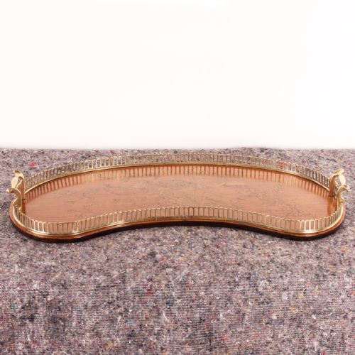 fig 1. A kidney-shaped satinwood serving tray featuring central floral marquetry inlay, a fitted brass gallery rim, and two side handles.