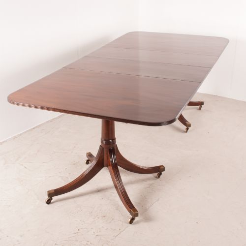 fig 1. A mahogany twin pillar extending dining table featuring rounded table corners, reeded sabre legs, and brass castors.