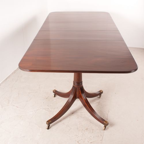 fig 2. A mahogany twin pillar extending dining table featuring rounded table corners, reeded sabre legs, and brass castors.
