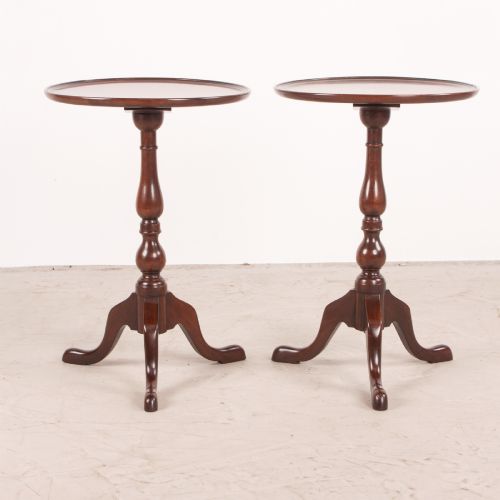fig 1. A matching pair of dark mahogany wine tables featuring dished circular tops, turned central pedestals, and splayed tripod legs.