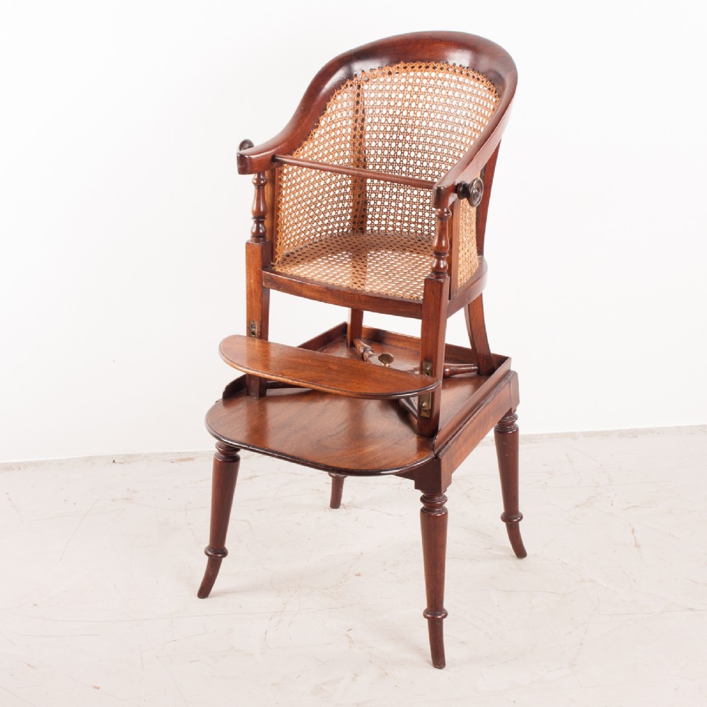 A 19th-century childs tub high chair crafted from rich mahogany with woven cane panelling and turned front legs.
