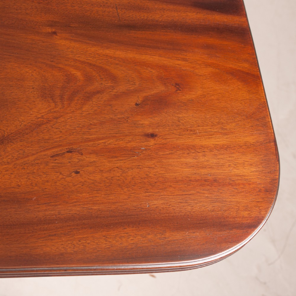 A mahogany twin pillar extending dining table featuring rounded table corners, reeded sabre legs, and brass castors. View XIV