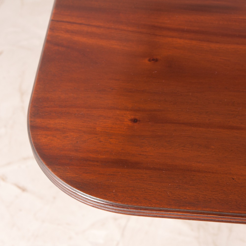 A mahogany twin pillar extending dining table featuring rounded table corners, reeded sabre legs, and brass castors. View XV