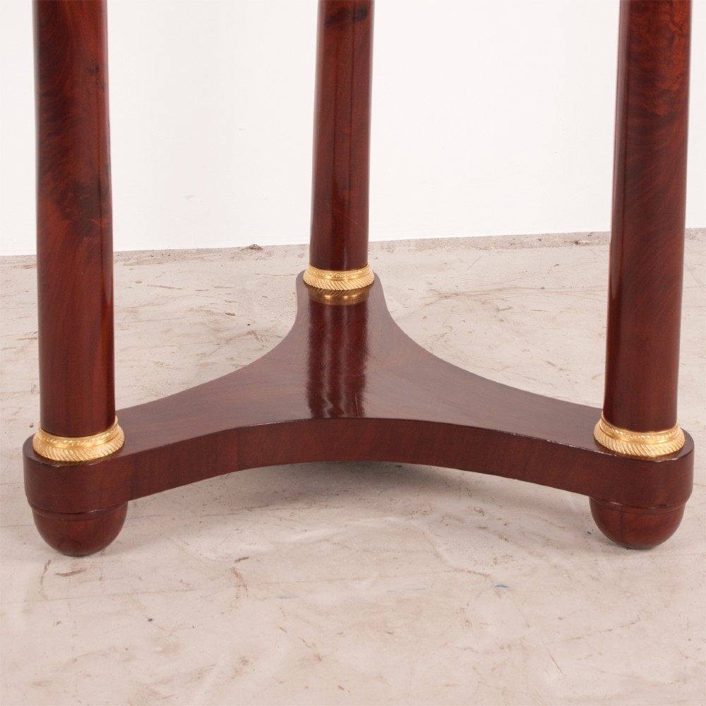 A 19th-century French mahogany gueridon side table with a round grey marble top, three cylindrical legs with gilt mounts, and a tri-form concave base. View IX