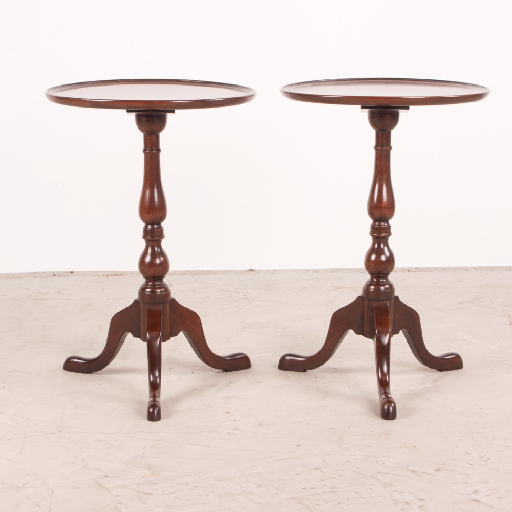 A matching pair of dark mahogany wine tables featuring dished circular tops, turned central pedestals, and splayed tripod legs. View II