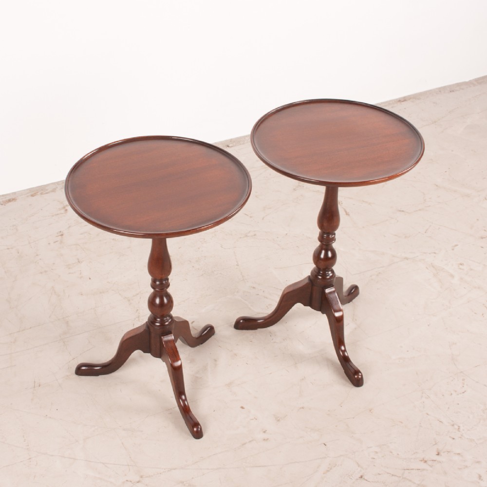 A matching pair of dark mahogany wine tables featuring dished circular tops, turned central pedestals, and splayed tripod legs. View IV