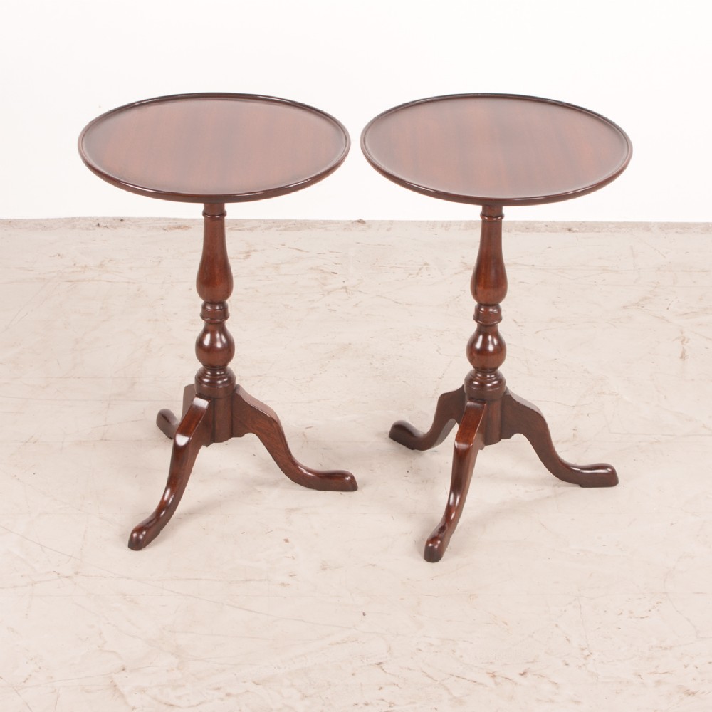 A matching pair of dark mahogany wine tables featuring dished circular tops, turned central pedestals, and splayed tripod legs. View V