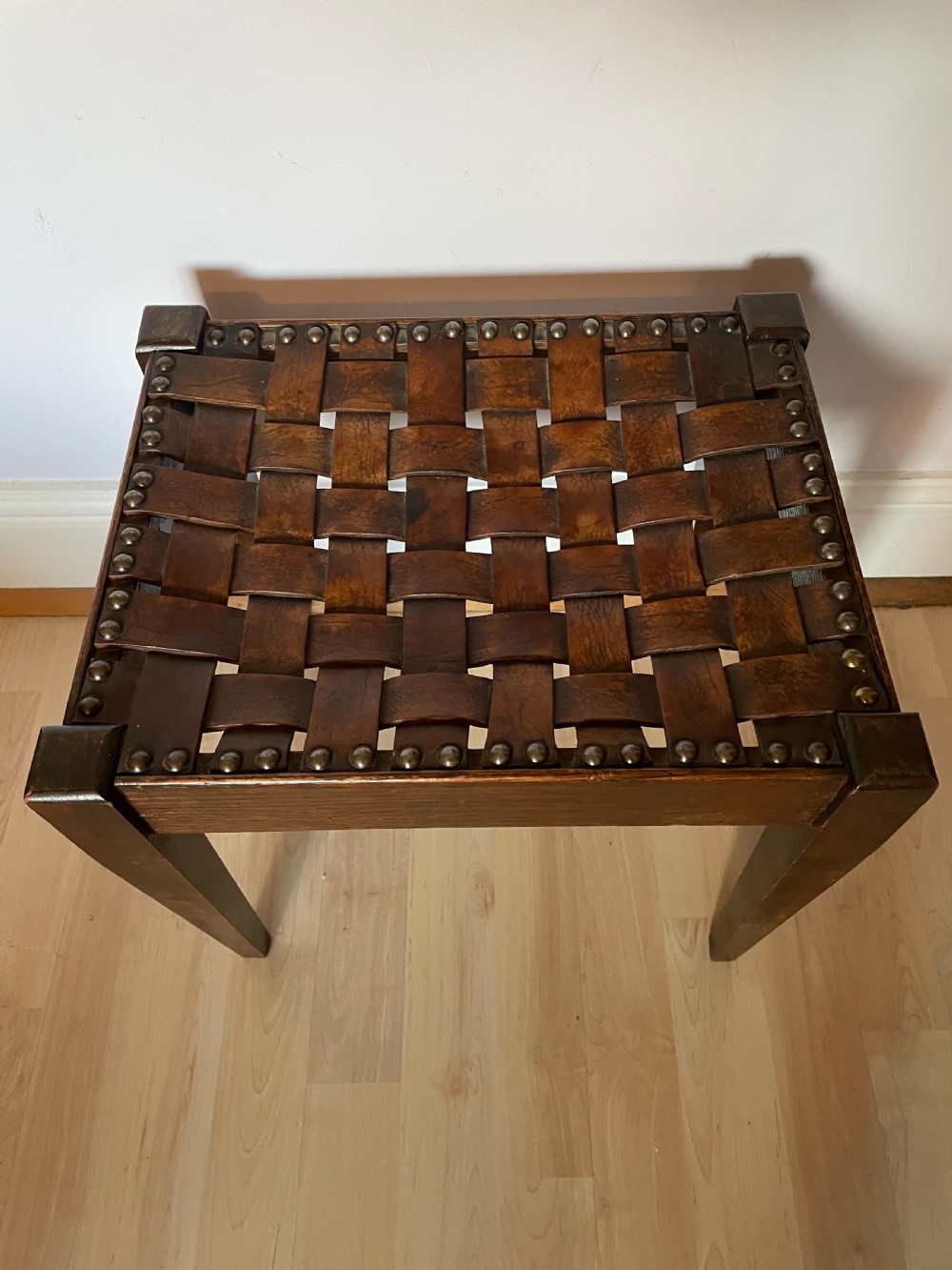 An Arts and Crafts oak and leather stool, attributed to Arthur Simpson View II