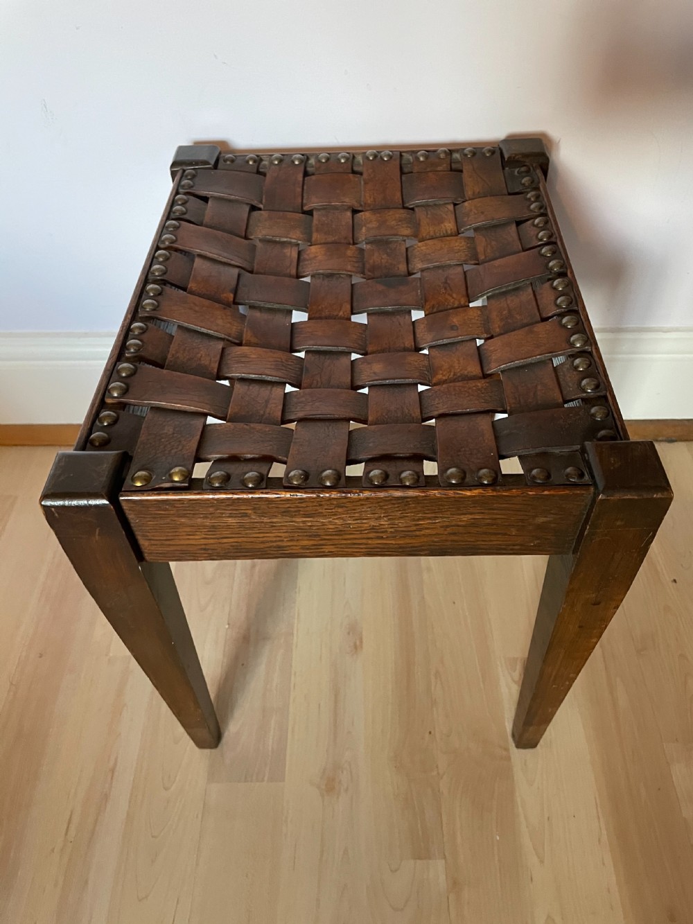An Arts and Crafts oak and leather stool, attributed to Arthur Simpson View III