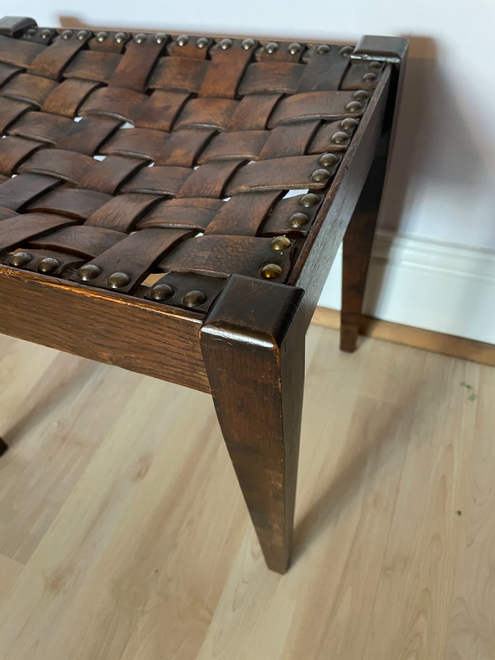 An Arts and Crafts oak and leather stool, attributed to Arthur Simpson View V