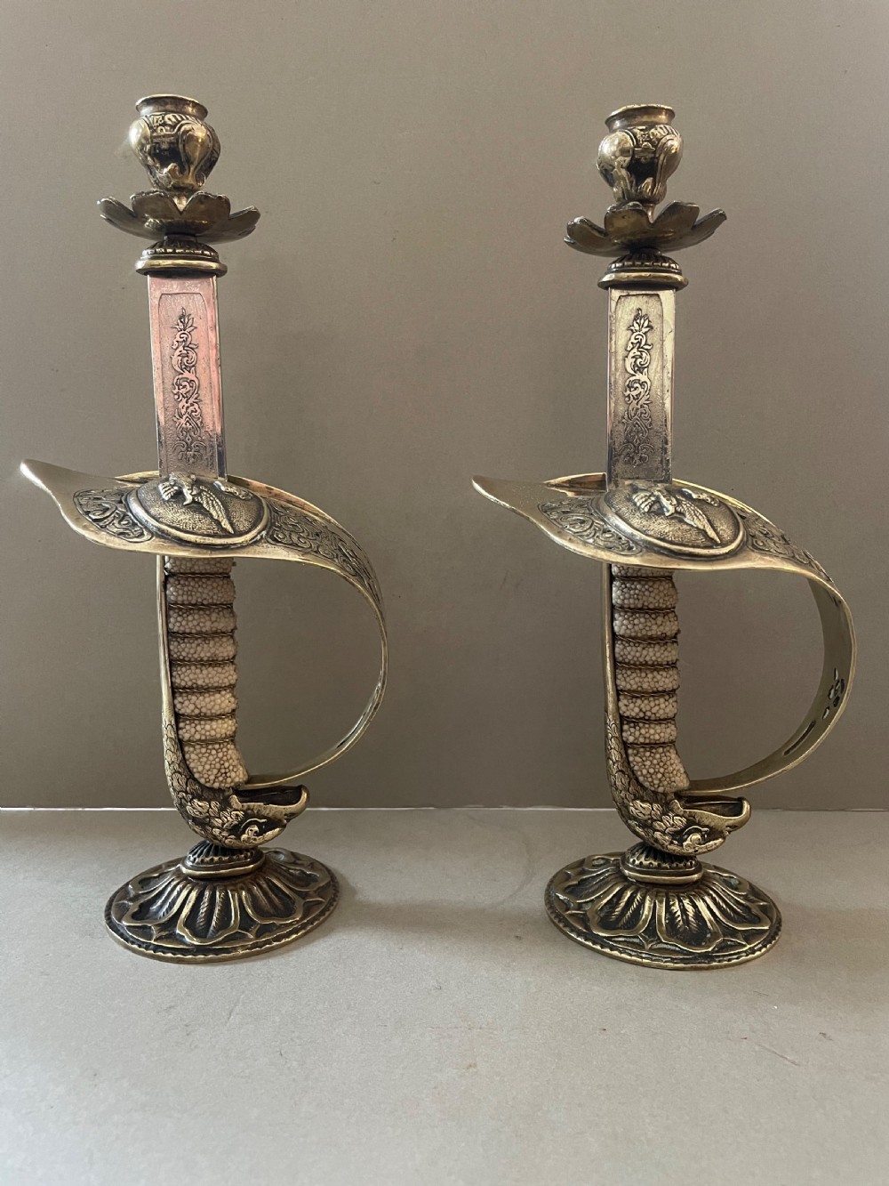 An antique pair of sword candlesticks