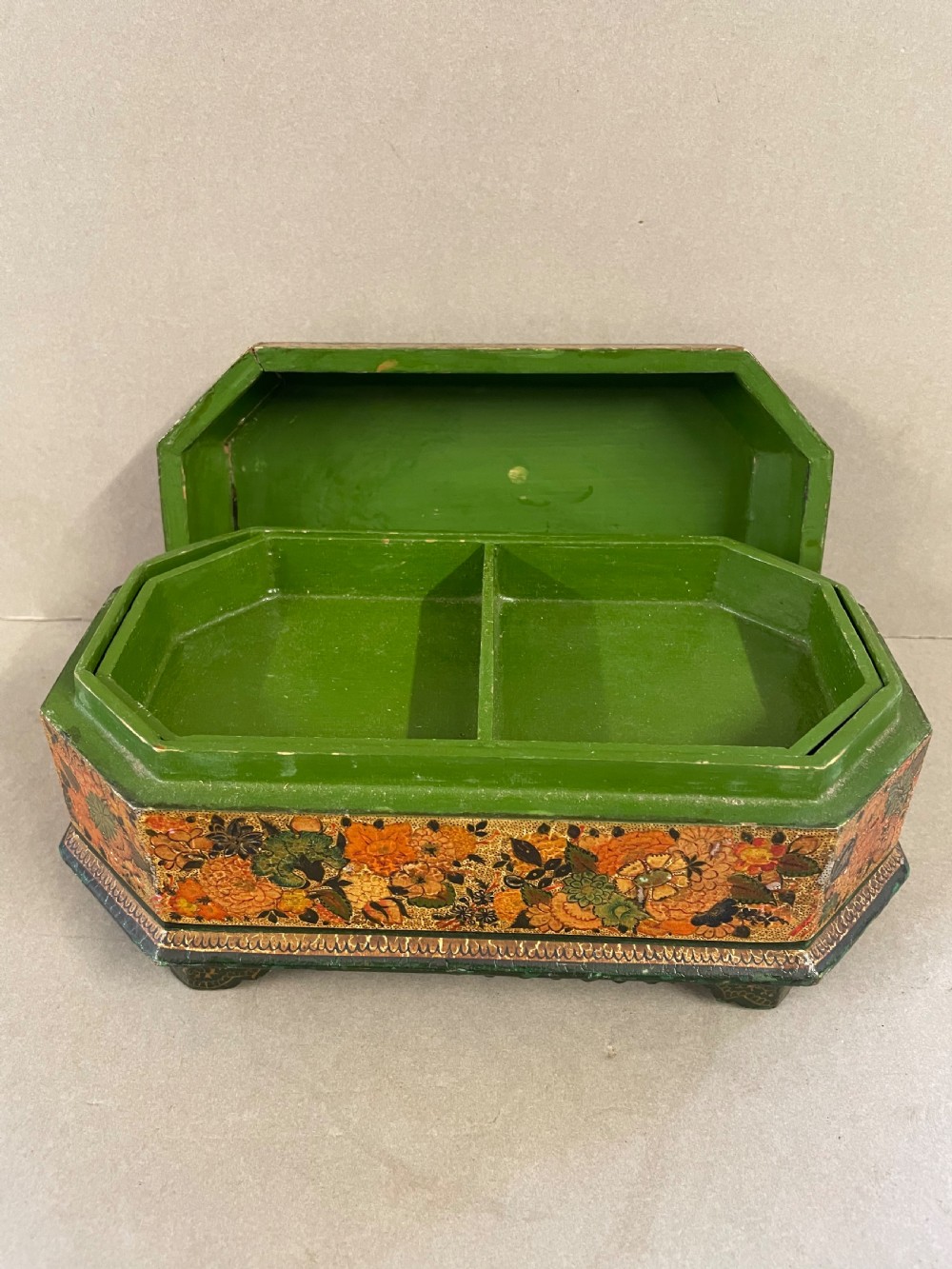 An antique octagonal papier-mache casket featuring intricate hand-painted floral and paisley patterns in green, gold, orange, and black tones. View IV