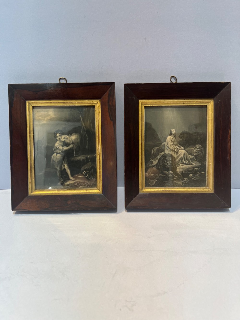 A pair of small framed antique engravings featuring religious figures set within wide dark rosewood frames with inner gilt slips.
