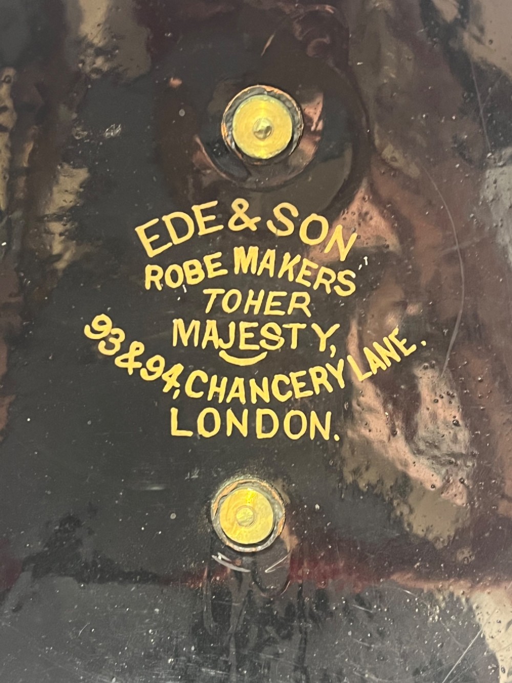 An antique horsehair barrister wig displayed on an internal wire stand next to a black painted metal tin case featuring gold lettering. View VII