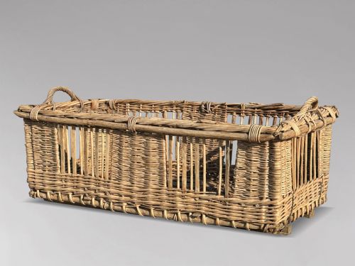 fig 1. A large rectangular French wicker basket featuring open vertical weave, woven loop handles, and wooden runner skids along the base.