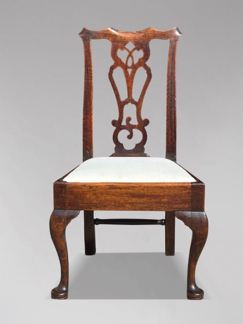 fig 2. A pair of 18th-century George III oak Chippendale side chairs featuring carved pierced splats, upholstered drop-in seats, and cabriole front legs.
