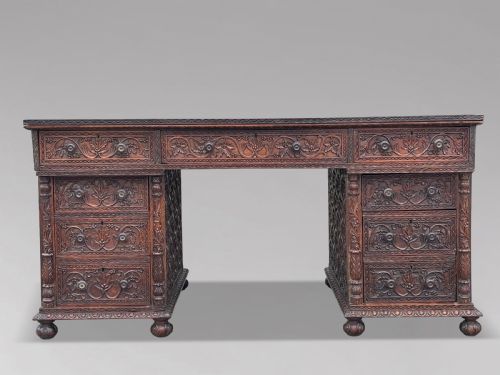 fig 1. Nineteenth-century Anglo-Indian carved padauk partners desk featuring intricate foliate relief carvings across the pedestal drawers and side panels on turned bun feet.