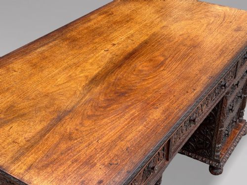 fig 2. Nineteenth-century Anglo-Indian carved padauk partners desk featuring intricate foliate relief carvings across the pedestal drawers and side panels on turned bun feet.