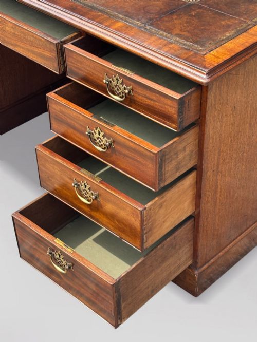 fig 3. An 18th-century George III mahogany partners desk featuring an inset leather writing surface, brass swan-neck handles, and twin pedestals with stacked drawers.