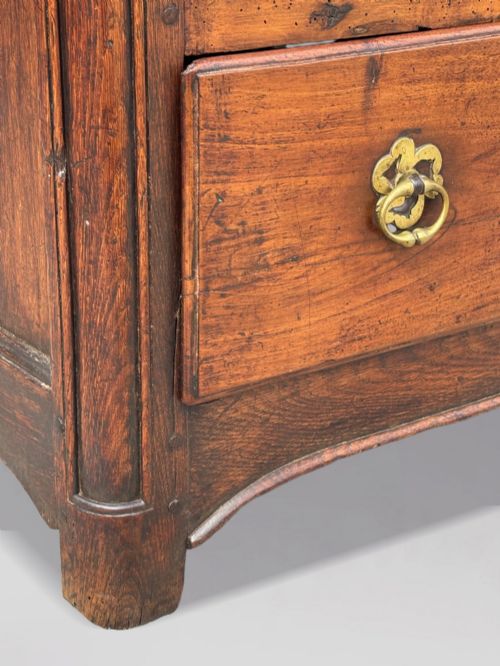 fig 3. A 17th-century French Provincial walnut commode featuring three long drawers decorated with brass drop handles and central escutcheons.