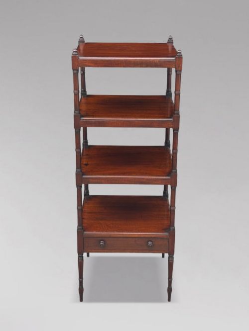 fig 1. A four-tier George III mahogany whatnot features turned corner columns topped with small finials and includes a single drawer built into the lowest shelf.