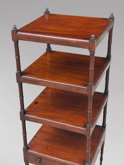 fig 2. A four-tier George III mahogany whatnot features turned corner columns topped with small finials and includes a single drawer built into the lowest shelf.
