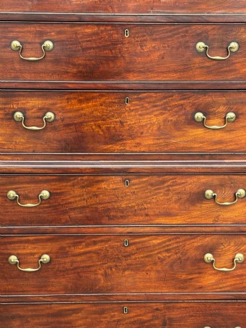 fig 3. An 18th-century George III mahogany chest on chest featuring upper and lower drawer sections with brass handles and bracket feet.