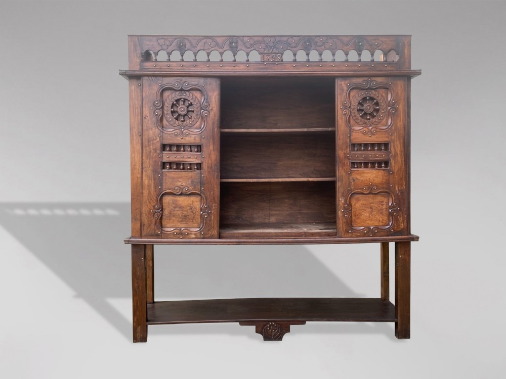A 19th-century carved dark wood Breton cupboard featuring spindle turnings, openwork geometric wheel motifs, and a gallery top raised on tall straight legs with an under-shelf. View III