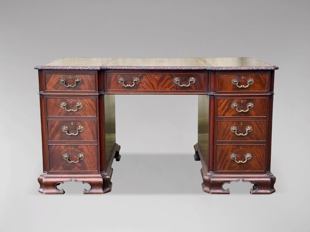 A nineteenth-century Chippendale style mahogany pedestal desk featuring a three-panel green leather writing top, nine drawers with brass handles, and bracket feet. View II