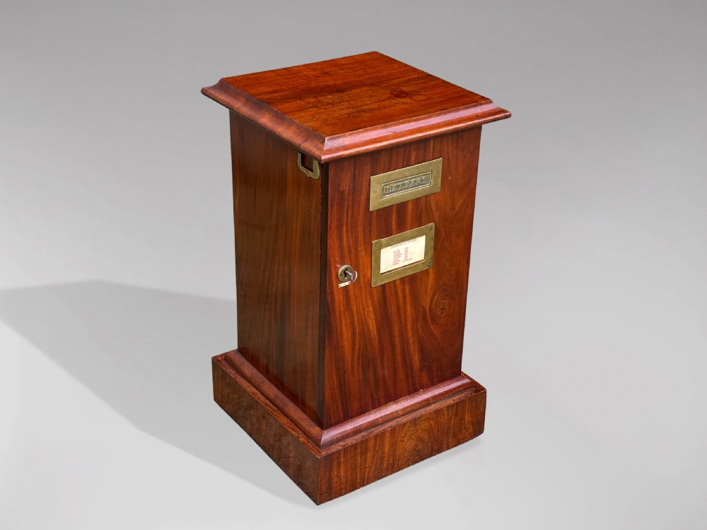 A 19th-century mahogany post box with a molded lid, brass letter slot, collection times plaque frame, and front key lock.