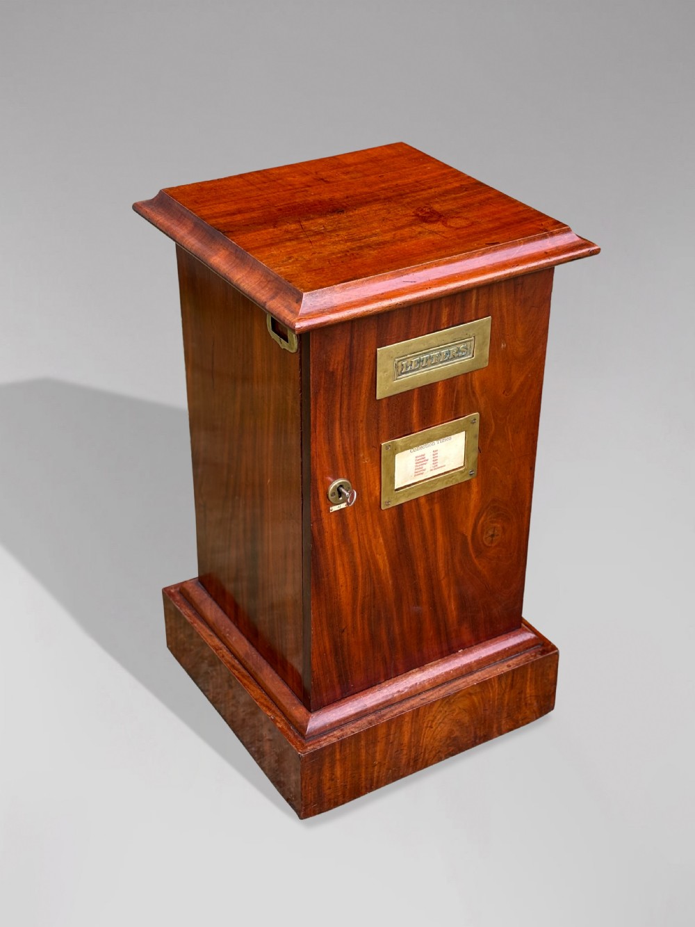 A 19th-century mahogany post box with a molded lid, brass letter slot, collection times plaque frame, and front key lock. View II
