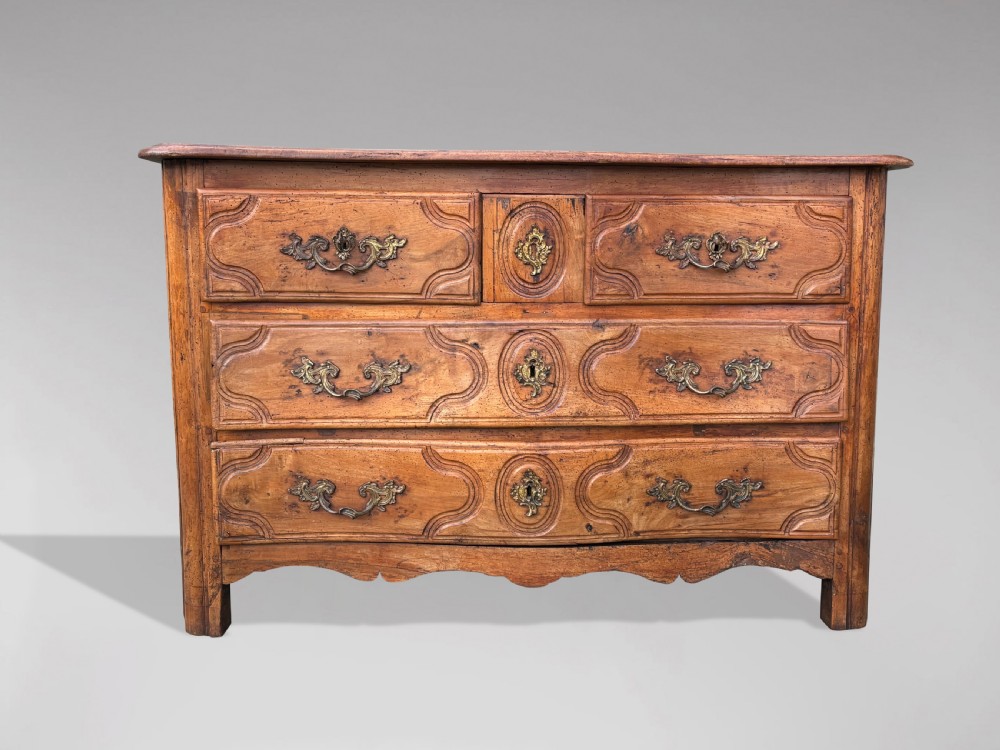 An 18th-century French Provincial walnut commode with three moulded drawers and decorative brass handles. View II