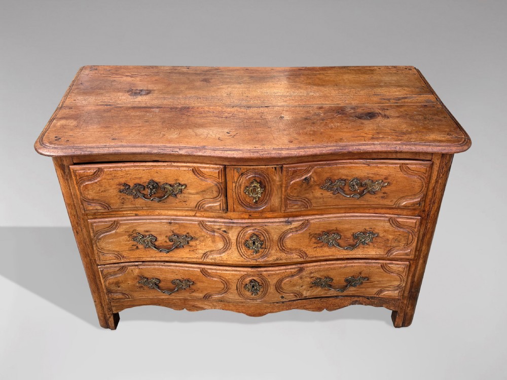 An 18th-century French Provincial walnut commode with three moulded drawers and decorative brass handles. View III