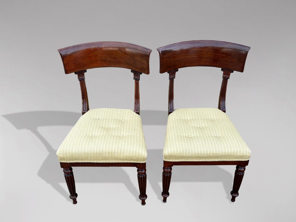 A pair of 19th-century William IV mahogany side chairs featuring curved top rails, fluted turned front legs, and pale yellow upholstered seats. View III