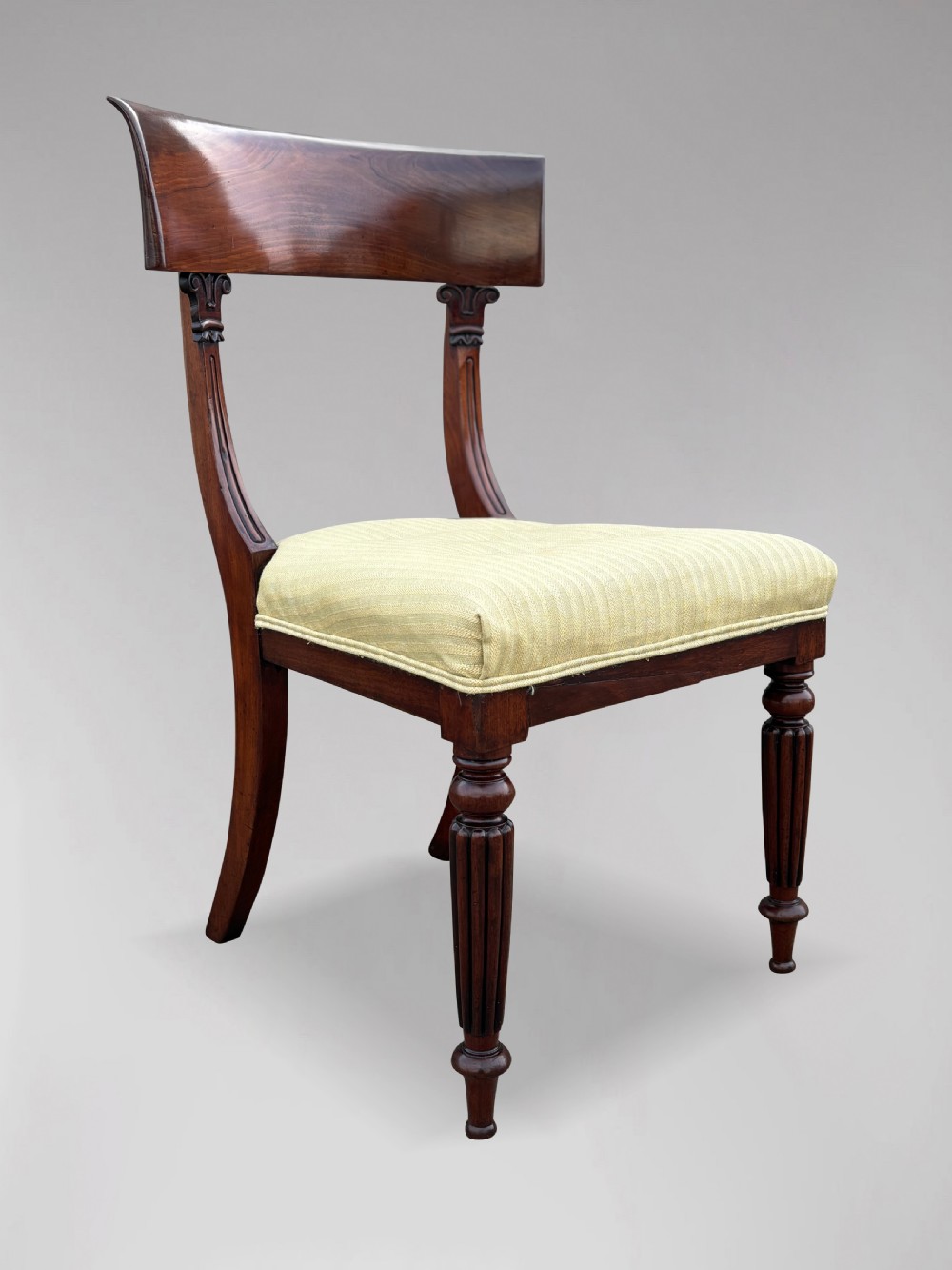 A pair of 19th-century William IV mahogany side chairs featuring curved top rails, fluted turned front legs, and pale yellow upholstered seats. View IV