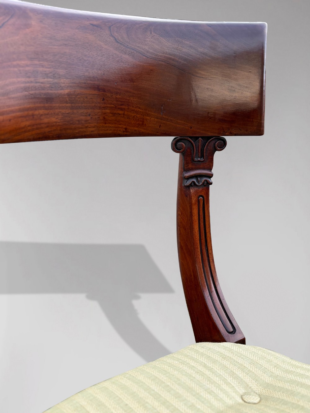 A pair of 19th-century William IV mahogany side chairs featuring curved top rails, fluted turned front legs, and pale yellow upholstered seats. View V
