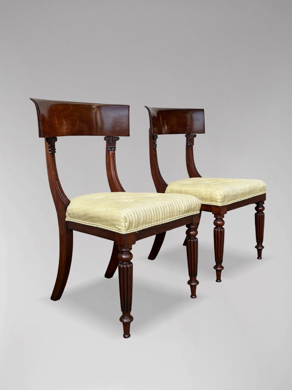 A pair of 19th-century William IV mahogany side chairs featuring curved top rails, fluted turned front legs, and pale yellow upholstered seats. View VII