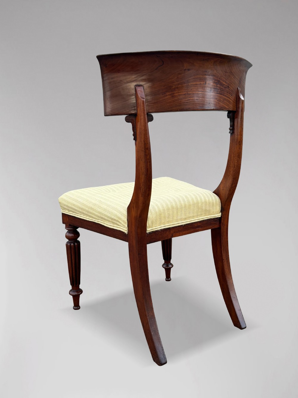 A pair of 19th-century William IV mahogany side chairs featuring curved top rails, fluted turned front legs, and pale yellow upholstered seats. View VIII